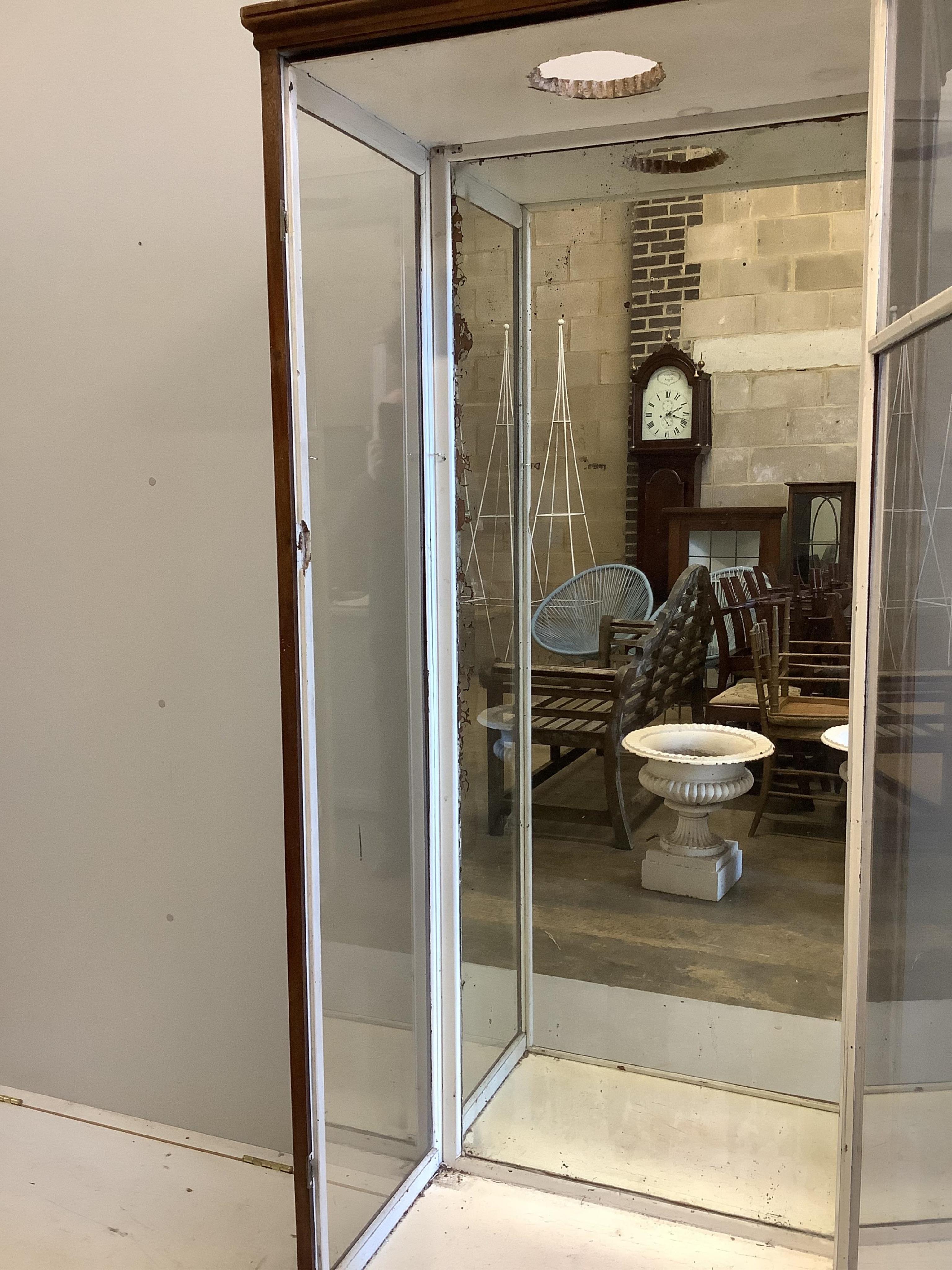 An early 20th century mirrored oak shop display cabinet, width 80cm, depth 47cm, height 189cm. Condition - poor, top has been cut to accommodate a light, lacks glass shelving